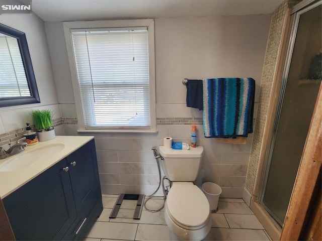 bathroom featuring a stall shower, vanity, tile walls, and tile patterned floors