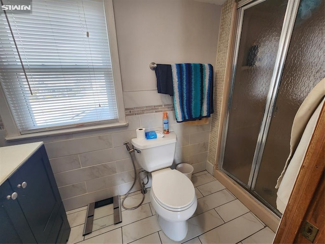 full bathroom featuring tile walls, toilet, vanity, a shower stall, and tile patterned floors