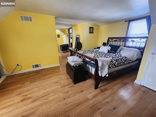 bedroom with light wood-style flooring, visible vents, and baseboards