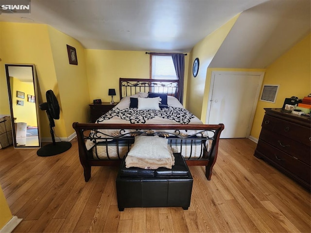 bedroom with light wood-type flooring, visible vents, and baseboards