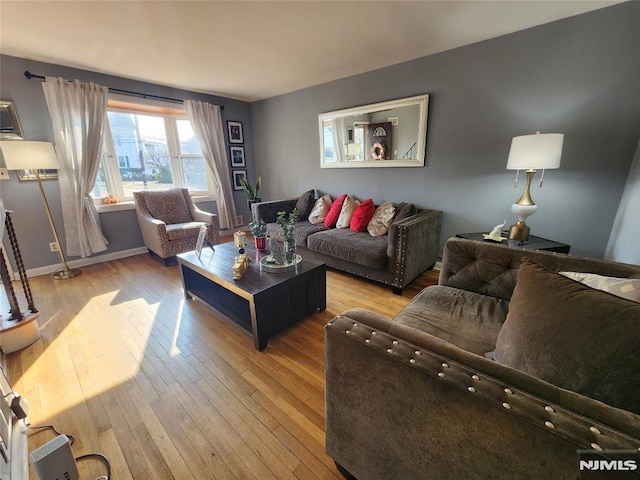 living area featuring hardwood / wood-style flooring and baseboards