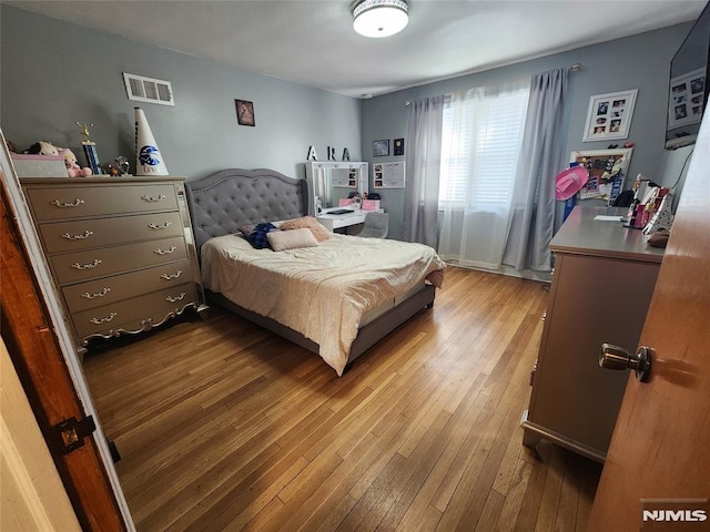 bedroom with hardwood / wood-style flooring and visible vents