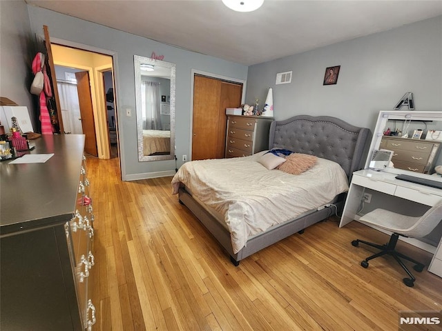 bedroom with baseboards, a closet, visible vents, and light wood-style floors