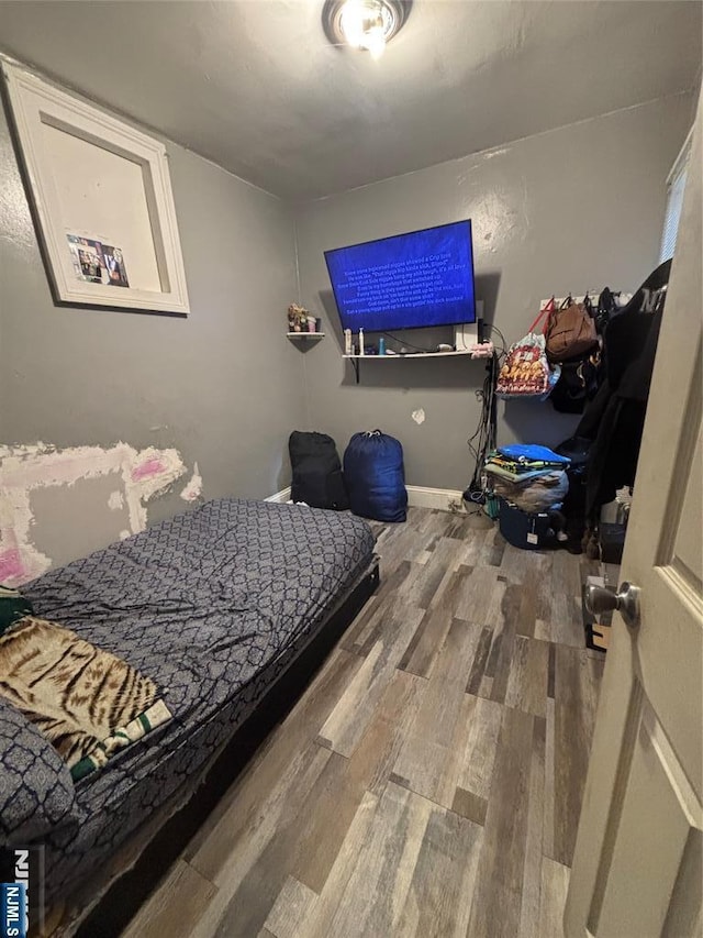 bedroom with wood finished floors and baseboards