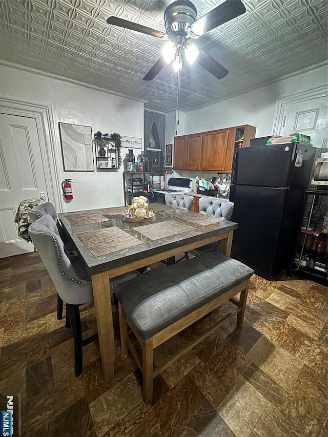 dining area featuring a ceiling fan and an ornate ceiling