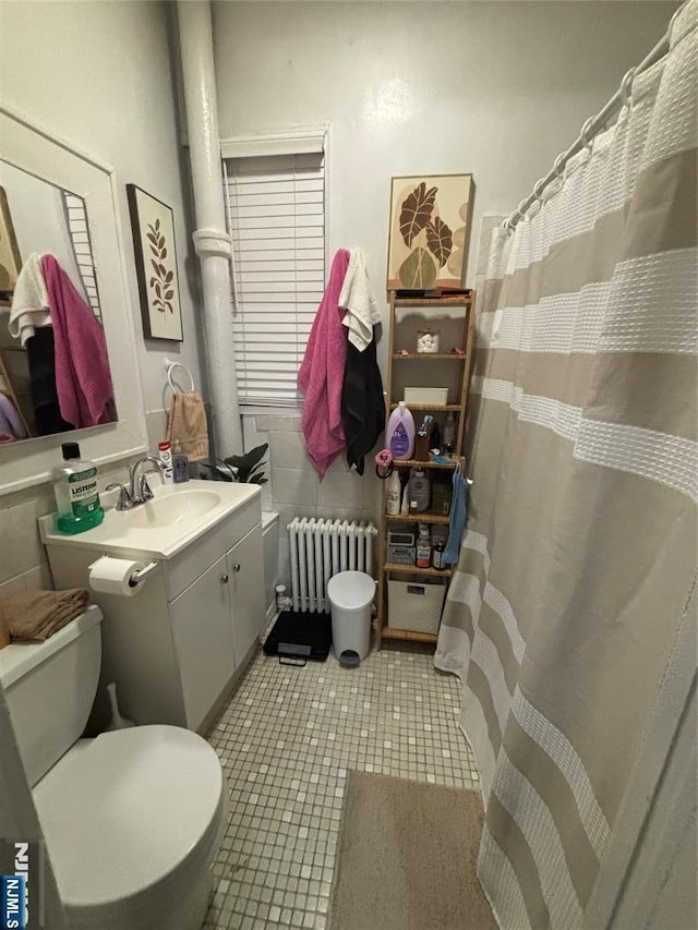 full bath with tile patterned flooring, curtained shower, toilet, radiator heating unit, and vanity