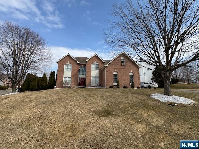 view of front of house with a front yard and brick siding