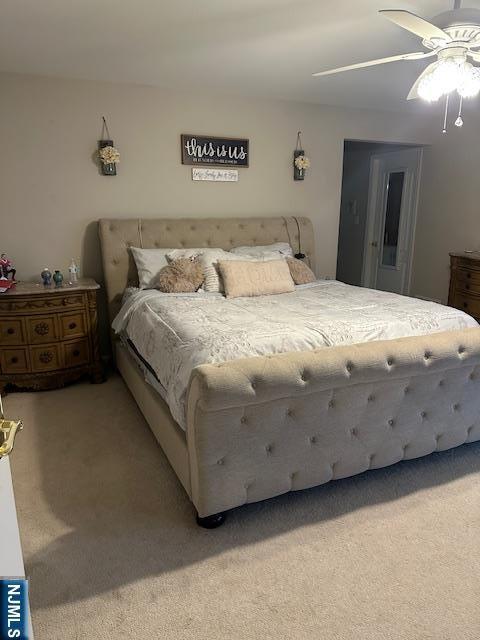 bedroom with light carpet and a ceiling fan