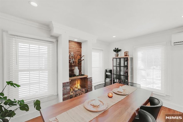 office area featuring wood finished floors, a wall mounted air conditioner, crown molding, a brick fireplace, and recessed lighting