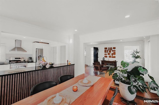 dining area featuring ornamental molding, wood finished floors, and recessed lighting