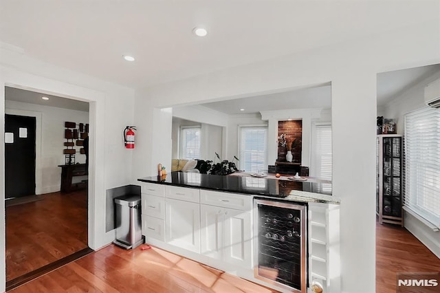 bar featuring beverage cooler, a dry bar, light wood-style flooring, and recessed lighting