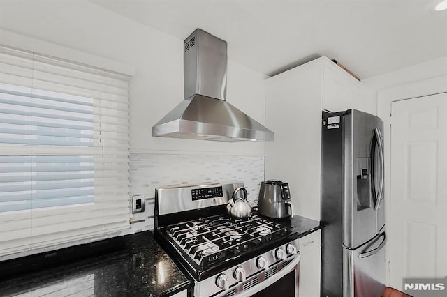 kitchen featuring stainless steel appliances, white cabinets, decorative backsplash, and wall chimney exhaust hood