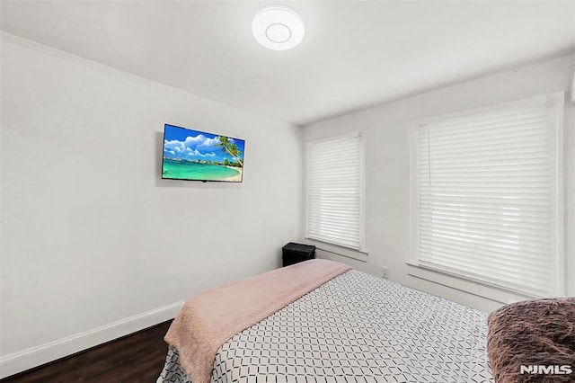 bedroom with dark wood finished floors and baseboards