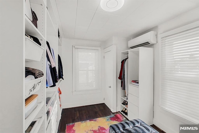 interior space featuring a wall unit AC and dark wood finished floors