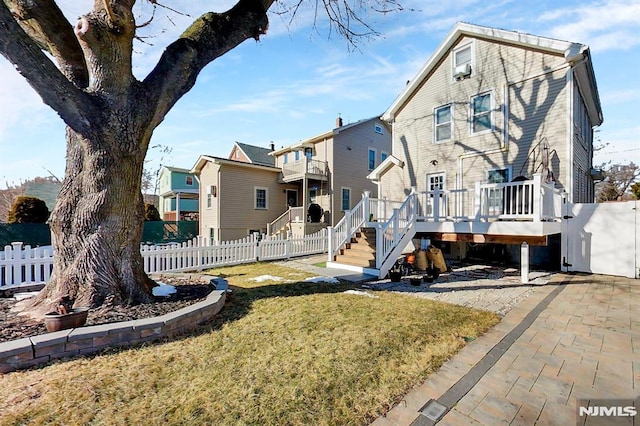 exterior space featuring fence private yard, a residential view, a deck, and a lawn