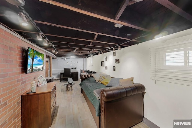 living area featuring light wood finished floors and brick wall