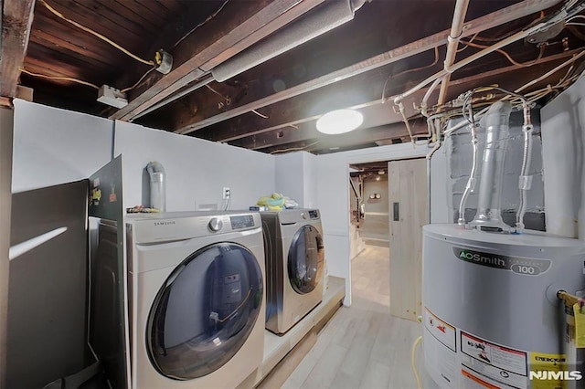 laundry area with light wood-style floors, gas water heater, separate washer and dryer, and laundry area