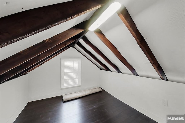 additional living space featuring lofted ceiling with beams and wood finished floors