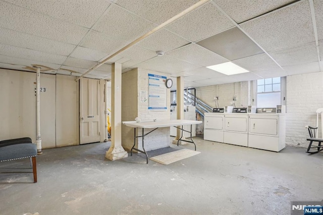 basement with washing machine and dryer and a drop ceiling