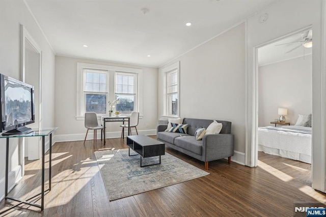 living area featuring ornamental molding, wood finished floors, and baseboards