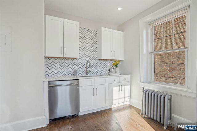 kitchen with a sink, light countertops, decorative backsplash, dishwasher, and radiator