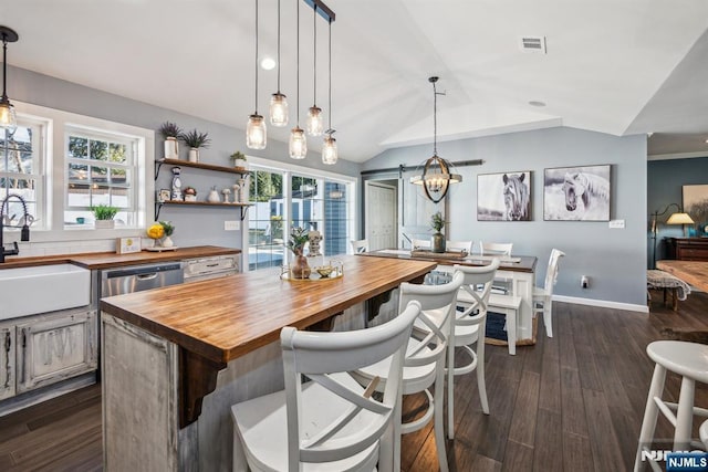 kitchen with visible vents, dark wood-type flooring, lofted ceiling, a sink, and wooden counters