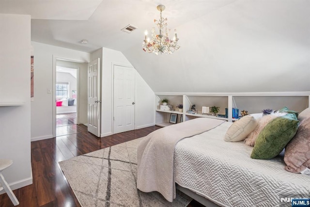 bedroom featuring visible vents, baseboards, lofted ceiling, hardwood / wood-style flooring, and a notable chandelier