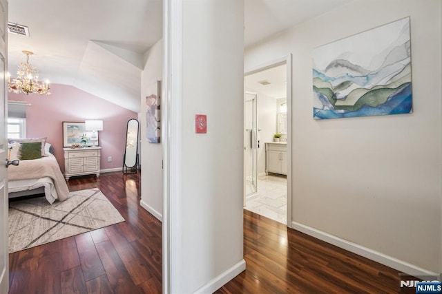 bedroom featuring visible vents, dark wood finished floors, baseboards, a chandelier, and vaulted ceiling