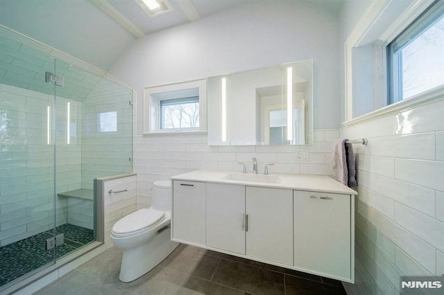 bathroom with toilet, a shower stall, tile walls, and tile patterned floors