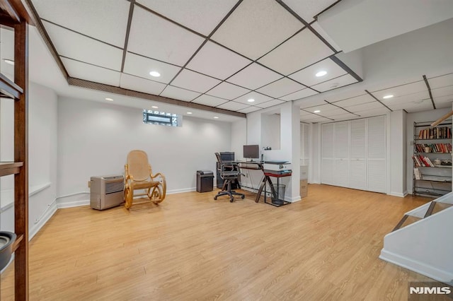 home office featuring baseboards, a drop ceiling, wood finished floors, and recessed lighting