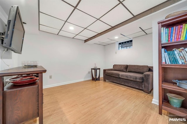 living room featuring baseboards, a drop ceiling, wood finished floors, and recessed lighting