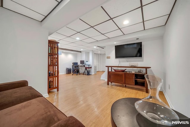 living room with a paneled ceiling, recessed lighting, light wood-style flooring, and baseboards