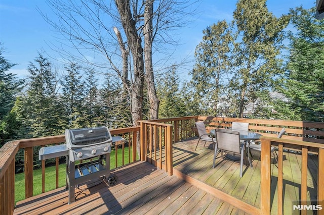 wooden deck with outdoor dining area and grilling area