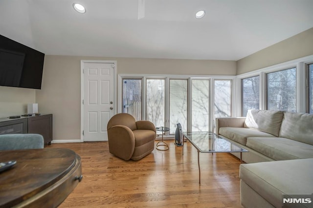 living area with recessed lighting, baseboards, and light wood finished floors