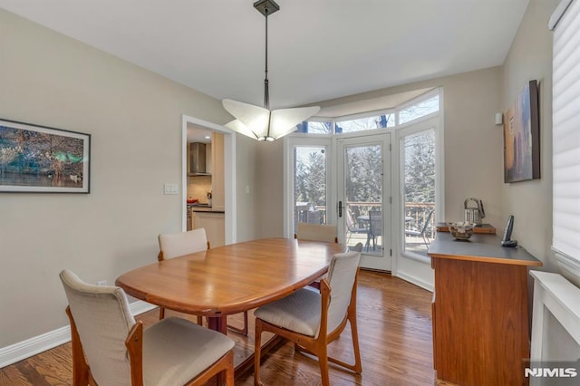 dining space with baseboards and wood finished floors