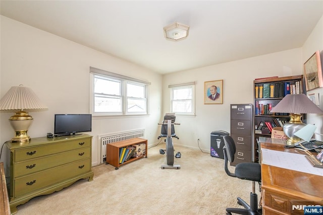 office featuring light carpet, radiator heating unit, and baseboards