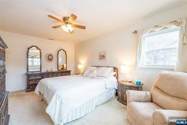 bedroom featuring ceiling fan, visible vents, and light colored carpet