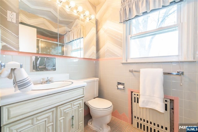 bathroom with radiator heating unit, tile walls, and vanity