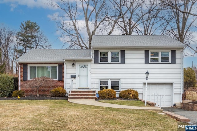 split level home with brick siding, roof with shingles, an attached garage, driveway, and a front lawn