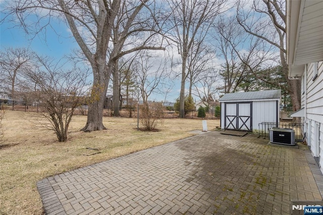 view of patio / terrace with a shed, fence, cooling unit, and an outbuilding