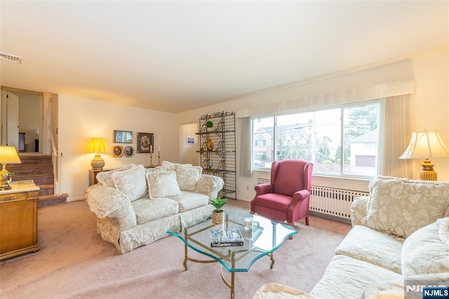 living area with stairs, carpet, visible vents, and radiator