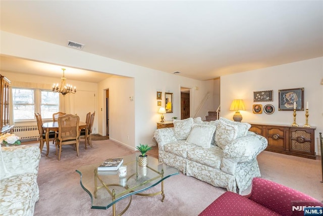 carpeted living room with a notable chandelier, visible vents, baseboards, stairway, and radiator heating unit