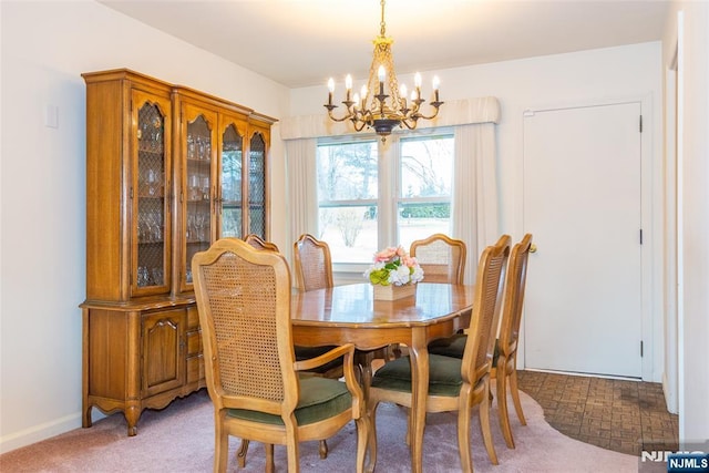 dining room featuring a notable chandelier and light colored carpet