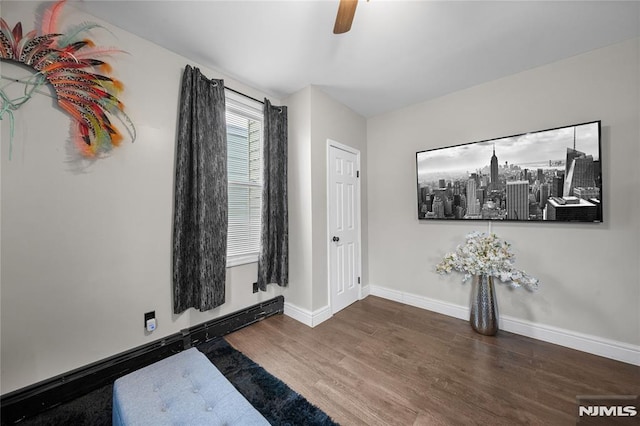 interior space featuring ceiling fan, baseboards, baseboard heating, and wood finished floors