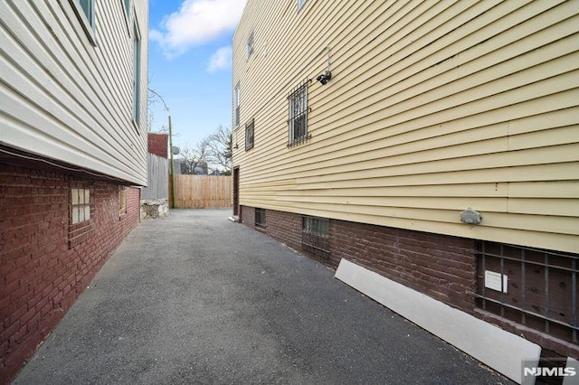 view of property exterior featuring a patio area and fence