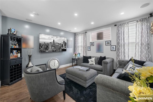 living area with baseboards, wood finished floors, and recessed lighting