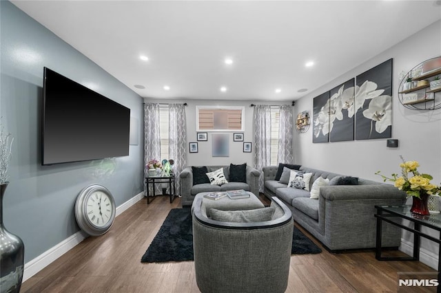 living area with a wealth of natural light, recessed lighting, baseboards, and wood finished floors