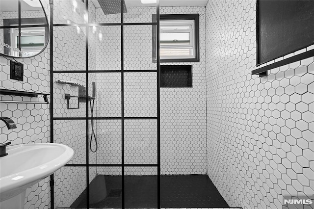 bathroom with a walk in shower and tile walls