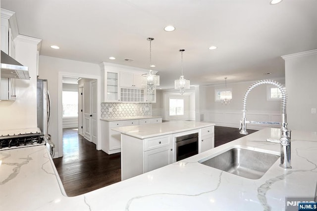 kitchen with backsplash, a sink, and white cabinetry