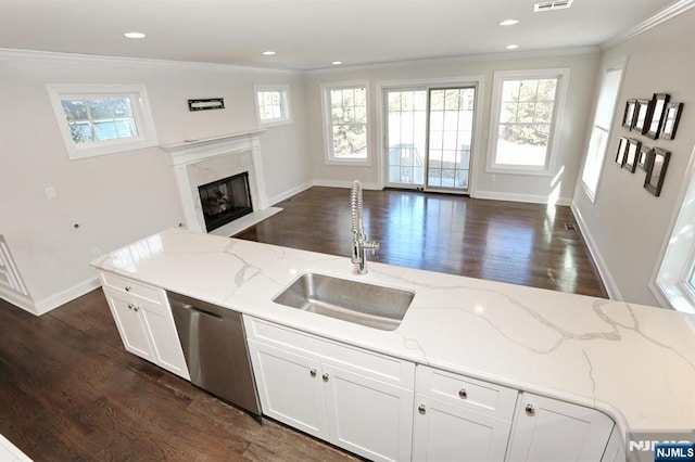 kitchen featuring dishwasher, ornamental molding, open floor plan, and a sink